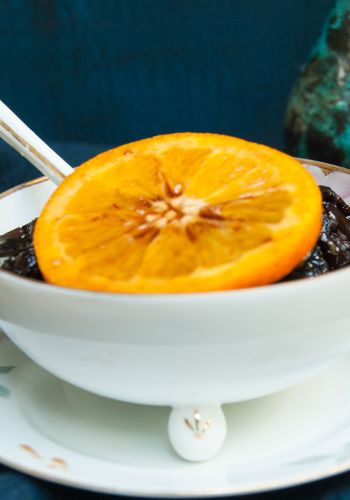 A Bowl Of Jam With A Slice Of Orange On A Plate