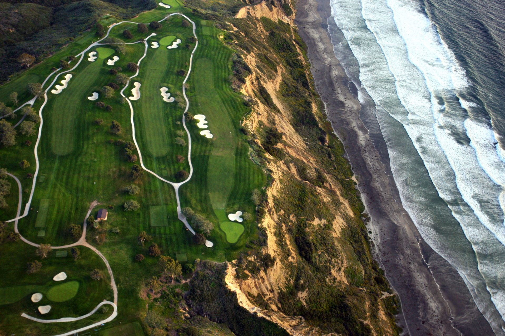 An Aerial View Of A Golf Course Next To The Sea